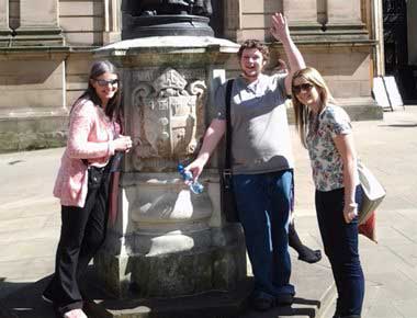 A team building group standing by a statue